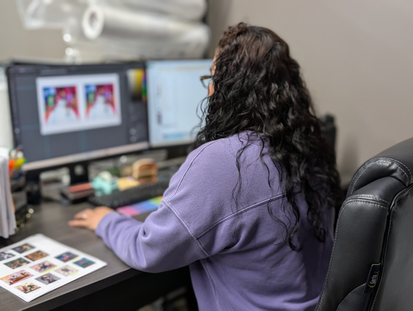 Color management workstation with dual monitors showing artwork calibration