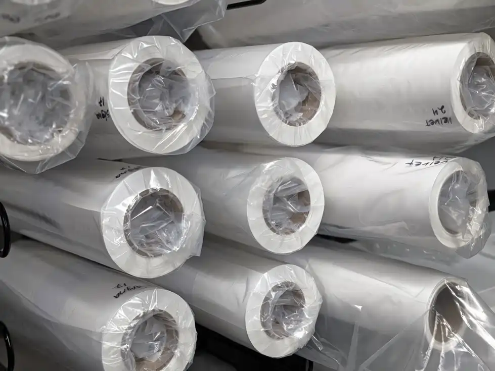 Rolls of fine art printing paper stacked on shelves — archival paper inventory at Picture This